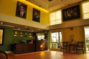 a restaurant with a waiting room with clocks on the walls at Chour Palace Hotel in Mae Sai
