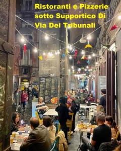 un grupo de personas sentadas en mesas en un restaurante en Napoli Forever, en Nápoles