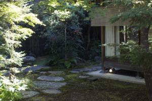 a garden with a window with a cat sitting on the window sill at Jeugiya in Kyoto
