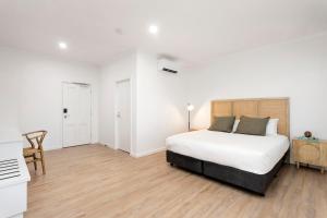 拜恩斯代尔Grand Terminus Hotel的卧室配有一张白色床和木地板