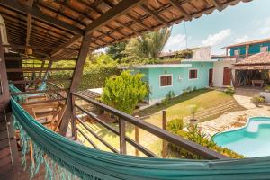 a hammock in the backyard of a house with a pool at Surfcamp Arara in Pipa