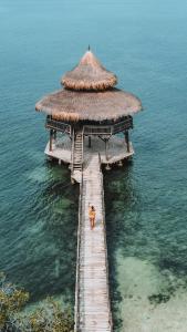 uma pessoa de pé numa doca na água em El Embrujo Tintipan em Tintipan Island