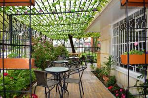 un patio al aire libre con mesas, sillas y plantas en Casa Hotel Santa Teresita, en Bogotá