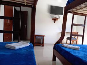 a bedroom with two bunk beds and a flat screen tv at Hotel Prestigio JC in Sogamoso
