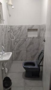 une salle de bain avec des toilettes bleues et un lavabo dans l'établissement Casa com Piscina 200 m da Praia - São Sebastião, à São Sebastião