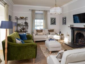 a living room with two couches and a fireplace at Bennar Fawr in Dyffryn