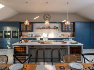 Bennar Fawr في Dyffryn: مطبخ مع دواليب زرقاء وجزيرة كبيرة