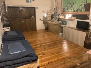 um quarto com uma cama e piso em madeira em With DiO em Setouchi