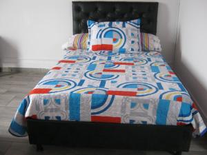 un letto con trapunta e cuscini sopra di ANGIE`s HOUSE a Manizales