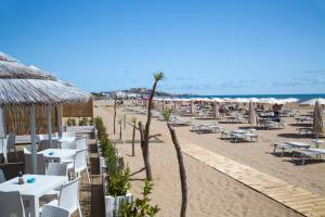 a beach with tables and chairs and the ocean at Garden Hotel Ripa in Vieste