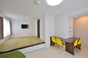 ein Esszimmer mit einem Tisch und gelben Stühlen in der Unterkunft Guest House Gifuhashima COCONE / Vacation STAY 33938 in Hashima