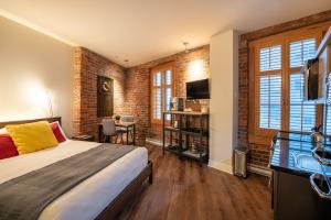 a bedroom with a bed and a brick wall at Appart-Hôtel Le Vincent in Quebec City