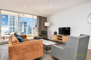 sala de estar con sofá, sillas y TV en QV Heart of City Stunning View with Parking - 1015, en Auckland