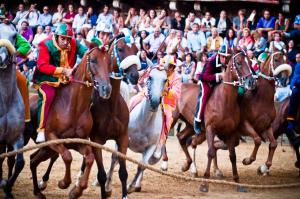 a group of jockeys riding horses at a horse race at Albergo Centrale in Siena