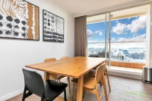 comedor con mesa y sillas y ventana grande en QV Heart of City Stunning View with Parking - 1015, en Auckland