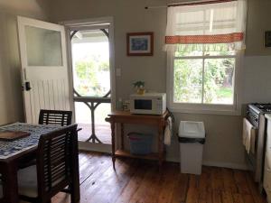 una cucina con un tavolo con un microonde e una finestra di Glenlyon Dam Holiday Cottage & Farmstay a Stanthorpe