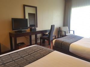 a hotel room with a desk and a television at Jiwa Jawa Resort Bromo in Bromo