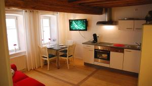 a kitchen with a table and chairs and a kitchen with a stove at Appartement Bamberg am Rathaus in Bamberg