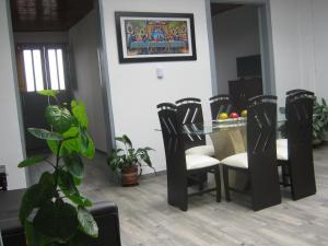 ANGIE`s HOUSE في مانيزاليس: غرفة طعام مع طاولة وكراسي زجاجية