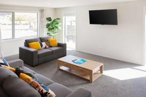 a living room with a couch and a coffee table at Josephine's Lakeside Star in Lake Tekapo