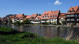 Appartement Bamberg am Rathaus في بامبرغ: مجموعة مباني بجانب نهر به بيوت