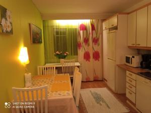 a kitchen and dining room with a table and a refrigerator at Apartment Haltijantie in Kotka +5 photos