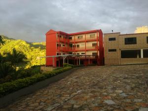 a red building sitting next to a brick street at Finca Hotel - Piscina La Johanna in La Mesa