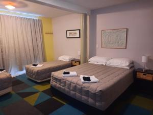 ein Hotelzimmer mit 2 Betten und Handtüchern darauf in der Unterkunft Mountain House in Arthur's Pass