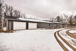un edificio con due porte garage nella neve di Quiet Lakefront Grand Rapids Cabin on 5 Acres a Grand Rapids