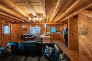 Cabaña de madera con sala de estar y cocina. en Treetops Cabin easy to Asheville with fast wifi and great view en Swiss