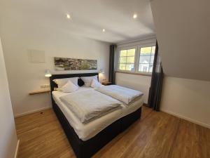 a bedroom with a large bed and a window at Weingut Lehnert-Veit Gutshotel in Piesport