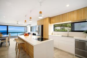 cocina con armarios blancos y vistas al océano en Absolute Beach Front Renovated 3 Bdrm 2 Bath App, en Gold Coast
