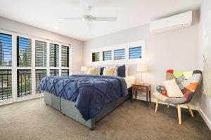 1 dormitorio con 1 cama, 1 silla y ventanas en Absolute Beach Front Renovated 3 Bdrm 2 Bath App, en Gold Coast