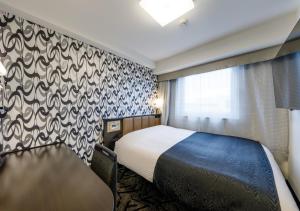 Säng eller sängar i ett rum på APA Hotel Hakata Gion Ekimae