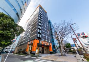 un edificio alto en la esquina de una calle en APA Hotel Hakata Gion Ekimae, en Fukuoka