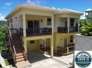 a house with balconies and stairs on it at Keep Cool Guesthouse in Gros Islet