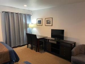 a hotel room with a desk with a television and a bed at Valley Hi Hotel in Winter Park