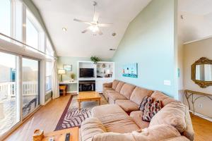 a living room with a couch and a large window at Under The Boardwalk in Avon