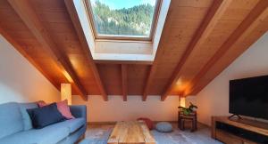 ein Wohnzimmer mit einem blauen Sofa und einem Fenster in der Unterkunft Apartment Honegg in Lauterbrunnen