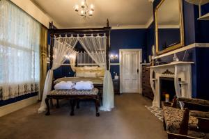 a bedroom with a canopy bed and a fireplace at Heytesbury House in Cobden