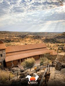 a building in the desert with a cow standing in front of it at Karivo in Windhoek +9 photos