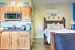 a bedroom with a bed and a kitchen with a sink at Albuquerque Studio with Shared Pool and Fire Pit! in Albuquerque