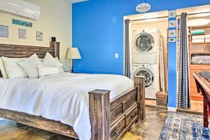 1 dormitorio azul con 1 cama y lavadora en Albuquerque Studio with Shared Pool and Fire Pit!, en Albuquerque