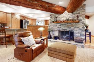 sala de estar con sofá y chimenea de piedra en Arrowhead Dream, en Lake Arrowhead