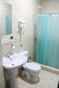 een badkamer met een toilet, een wastafel en een douche bij Orion Hotel Tashkent in Tasjkent