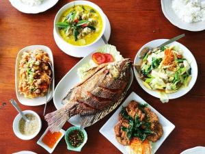 佛丕Vimannam Resort的一张木桌，上面摆放着食物盘子