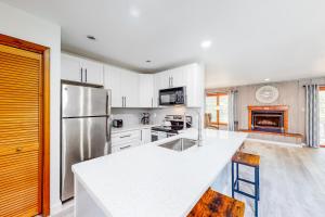 a kitchen with white cabinets and a stainless steel refrigerator at Mountainside Oasis in East Stroudsburg
