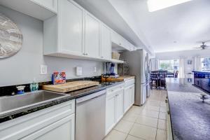 a kitchen with white cabinets and a sink at Coconut Grove 203 in Myrtle Beach