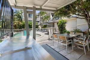 
a patio area with a patio table and chairs at Surf Dance Apartments in Coolum Beach
