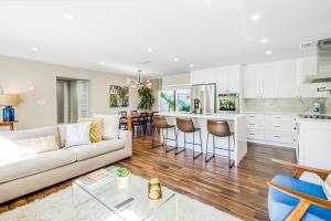 uma sala de estar com um sofá branco e uma cozinha em Mid-Century Modern Oasis em Miami
